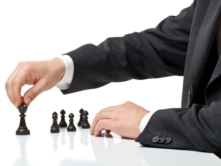 Business man moving chess figure with team behind - strategy or management conceptの写真素材