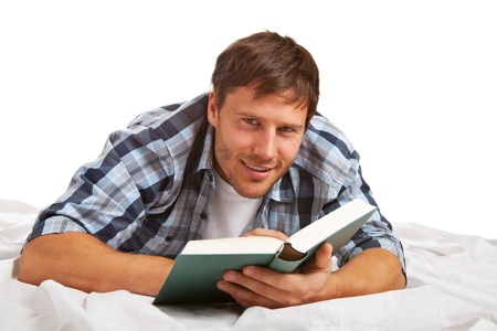 Young student reading a book, looking at camera, smilingの写真素材