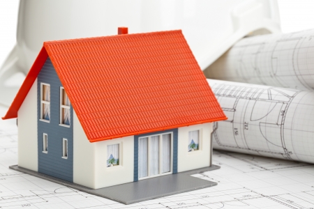 Model house on construction blueprints layed out on tableの写真素材