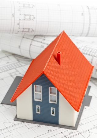 Model house on construction blueprints layed out on tableの写真素材