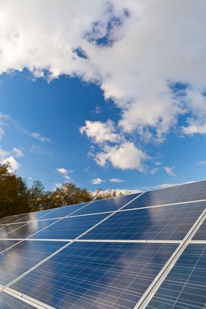 Solar photovoltaics panels field for renewable energy production with blue sky and cloudsの写真素材