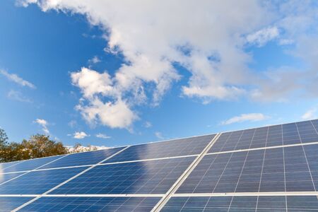 Solar photovoltaics panels field for renewable energy production with blue sky and cloudsの写真素材