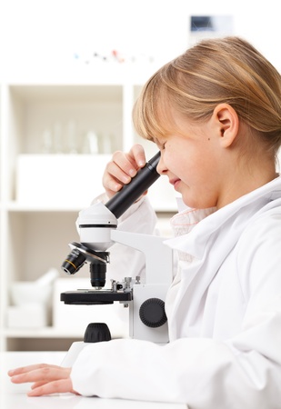 Young girl with microscope in school research labの写真素材