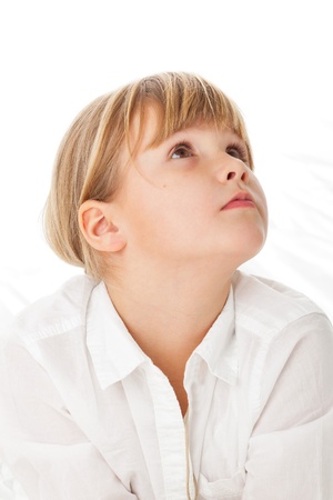 Young girl with white shirt over white background on bed dreamingの写真素材