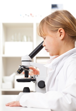 Young girl with microscope in school research labの写真素材