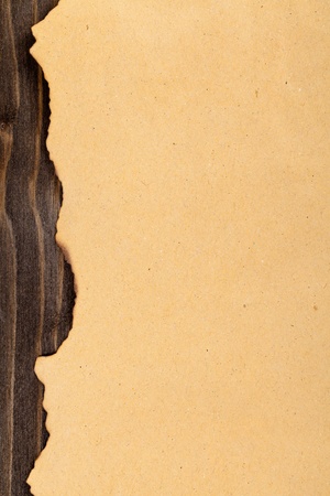 Empty old yellow paper with burned edge on wooden backgroundの写真素材