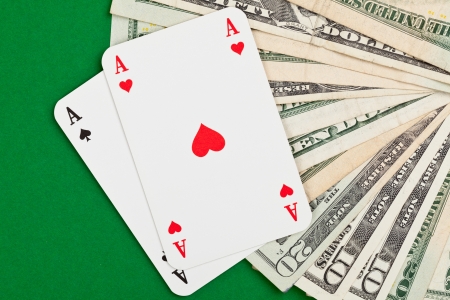 Pocket aces on dollar bills on poker tableの写真素材