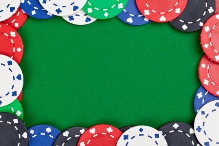 Different casino chips frame on green table background with copyspaceの写真素材