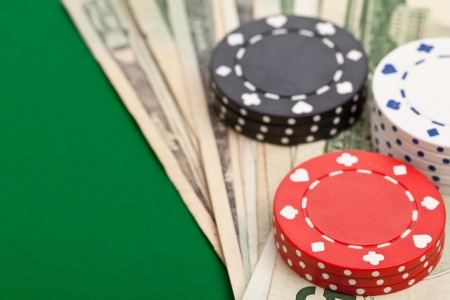 Casino chips on dollar bills on poker tableの写真素材
