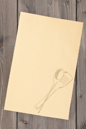 Empty paper for recipe with drawn cooking utensils on kitchen tableの写真素材