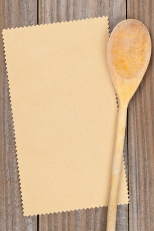 Empty paper for recipe with wooden cooking utensils on kitchen tableの写真素材