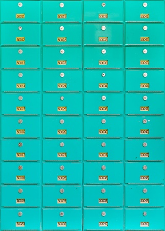 Large number of green metal mailboxes on wallの写真素材