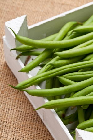 Organic pole beans in white wooden crateの写真素材