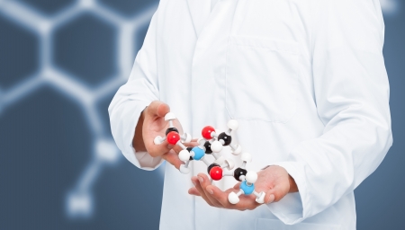 Scientist analyzing chemical molecule model with blue backgroundの写真素材