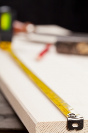 Wooden plank with measurement tape and tools with selective focusの写真素材