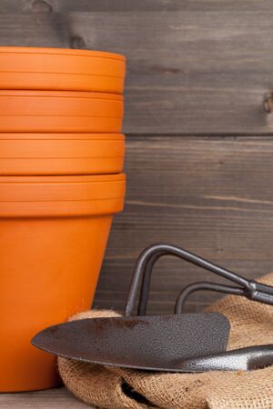Stacked empty plant pots and gardening equipment on wooden backgroundの写真素材