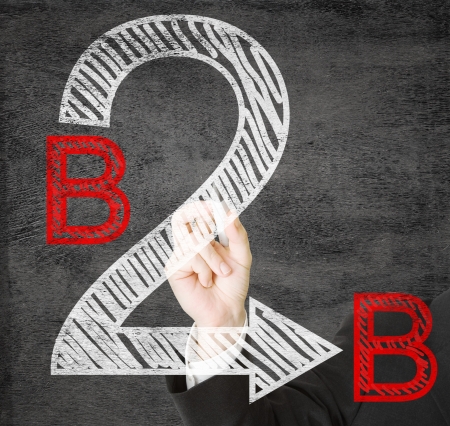 Hands writing B2B - business to business - on transparent screenの写真素材