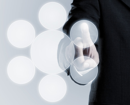 Businessman touching infogram graphics on virtual touchscreen with copy spaceの写真素材