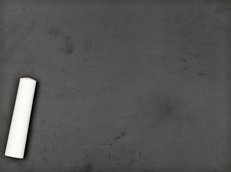 Old empty blackboard with piece of white chalkの写真素材