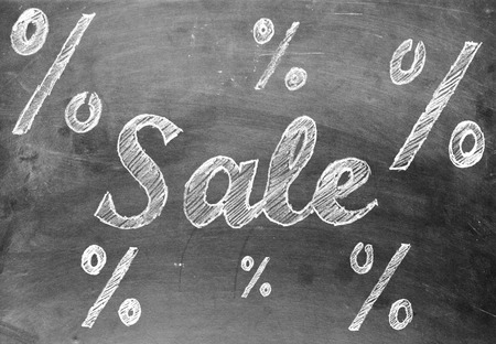 Sale chalk writing with percentage signs on old vintage black chalkboardの写真素材