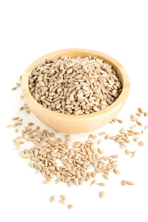 Natural shelled sunflower seeds in wooden bowl over white backgroundの写真素材