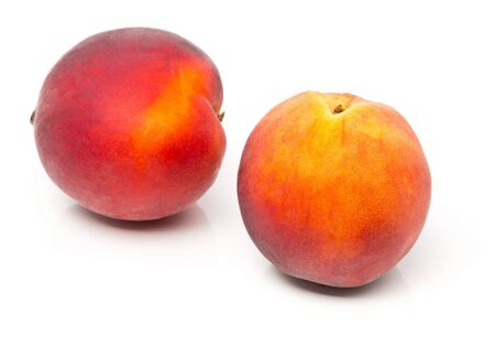 Two uncut, whole, ripe peaches fruit over white backgroundの写真素材