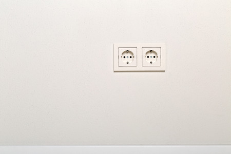 Empty, unplugged european wall outlet on white plaster wall with copy spaceの写真素材