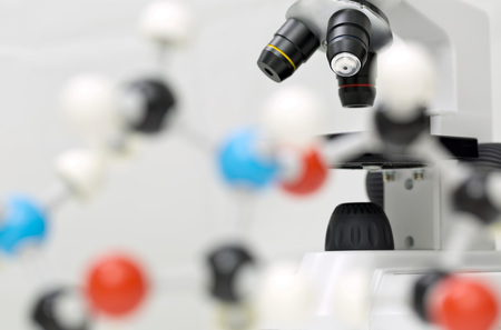 Microscope behind out of focus molecule model over white background
