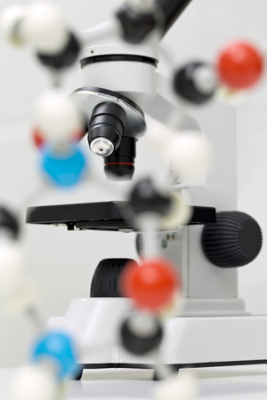 Microscope behind out of focus molecule model over white background