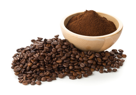 Coffee beans with ground coffee in wooden bowl over white backgroundの写真素材