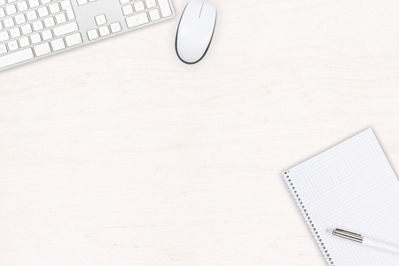 White wooden office desk top view with computer mouse, keyboard, notepad and pen with copy spaceの写真素材