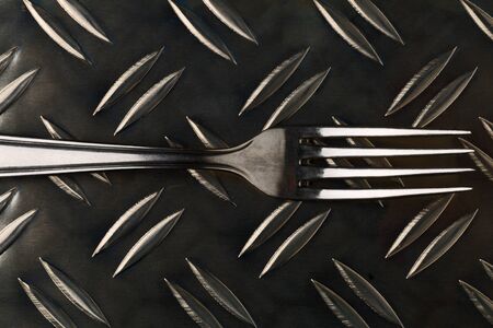 Metal fork top view on metal background
