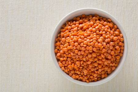 Raw red, dried  lentils in white bowl on tableの写真素材