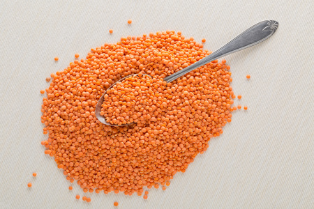 Raw red, dried  lentils in metal spoon on tableの写真素材