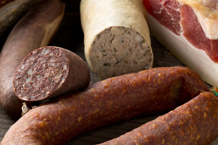 Assortment of german sausage specialties hard cured salami, liver sausage (Leberwurst), blood sausage (Blutwurst) and bacon on kitchen tableの写真素材