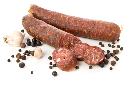 German specialty salami hard cured sausage whole and sliced with spices over white backgroundの写真素材