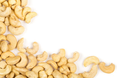 Corner of raw, organic, whole cashew nut kernels over white backgroundの写真素材
