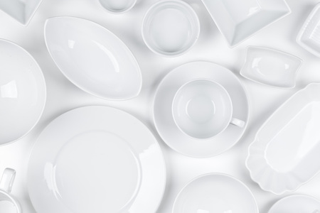 Empty, clean white assorted dishware with plates, cups and bowls white backgroundの写真素材
