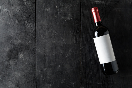 Red wine bottle on dark wooden table flat lay from above with copy spaceの写真素材