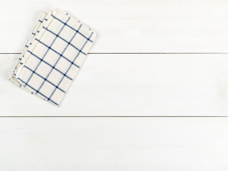 Blue and white checkered dishcloth on white wooden plank table flat lay top view from above with copy spaceの写真素材