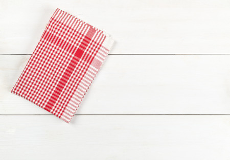 Red checkered dishcloth on white wooden plank table flat lay top view from above with copy spaceの写真素材