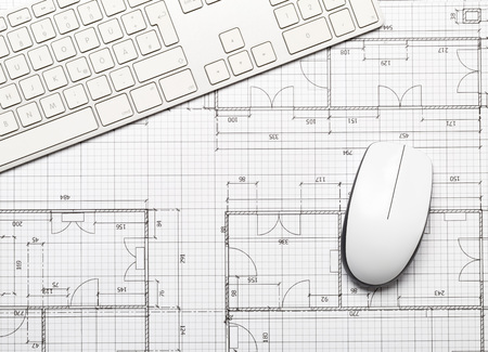 Architectural blueprint house building plan with computer keyboard and mouse on table flatlay top...