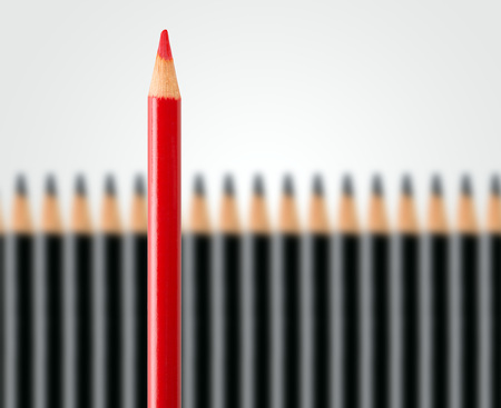 Business concept of disruption, leadership or think different; red pencil in row of black pencils standing out; minimal concept flat lay from above on white backgroundの写真素材
