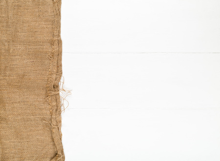 Burlap fabric cloth on white wooden kitchen table with copy spaceの写真素材