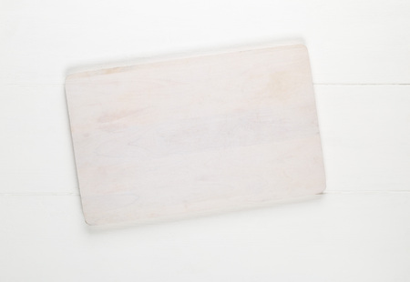 Empty white cutting board on white wooden table background top view from above with copy spaceの写真素材