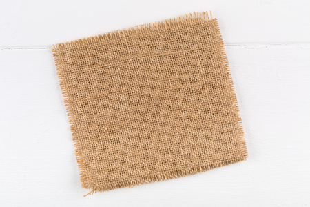 Burlap fabric cloth on white wooden kitchen table with copy spaceの写真素材