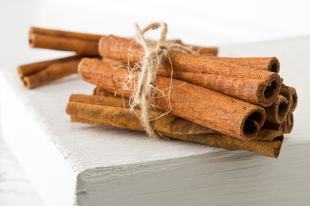 Tied dried cinnamon sticks onwhite board on table background - selective focusの写真素材