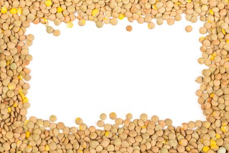 Raw, dry, uncooked brown lentil legumes frame border texture background flat lay top view from above with copy spaceの写真素材