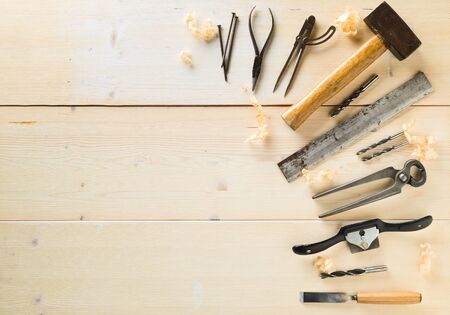 Collection of old, used wood working tools flat lay from above on light wooden background with copy space - repair, craftsmanship or workshop conceptの写真素材