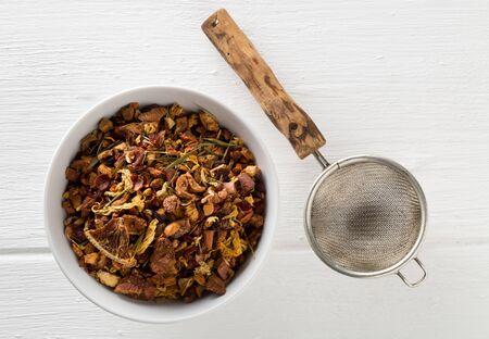 Heap of dried fruit tea infusion with oranges and strawberries mixed with tea leaves and assorted...
